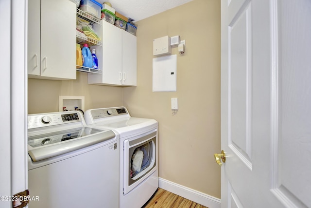 4670 Links Village Dr Unit B102, Ponce Inlet, FL 32127 - laundry room featuring separate washer and dryer, cabinet space, baseboards, and light wood-style floors