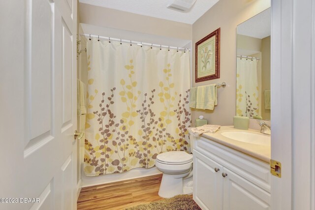 4670 Links Village Dr Unit B102, Ponce Inlet, FL 32127 - bathroom with vanity, toilet, wood finished floors, and shower / tub combo with curtain
