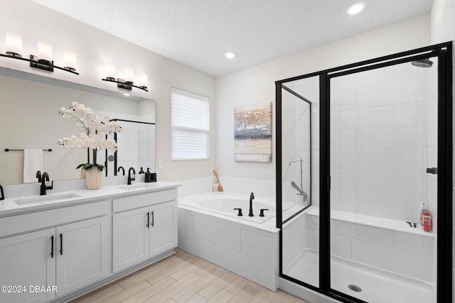 bathroom featuring wood-type flooring, independent shower and bath, and vanity