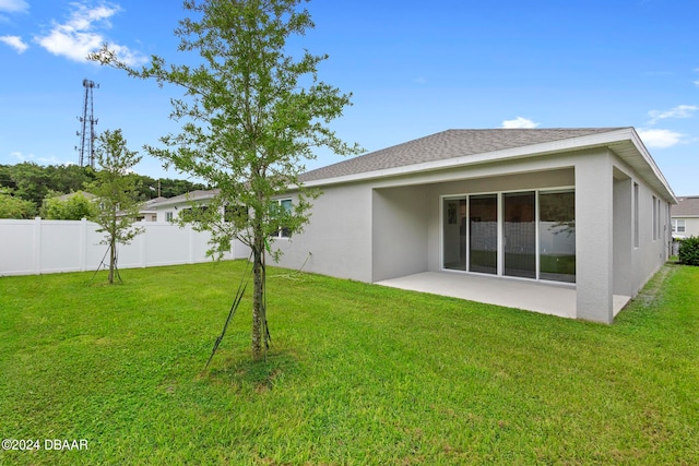 back of house featuring a patio and a yard