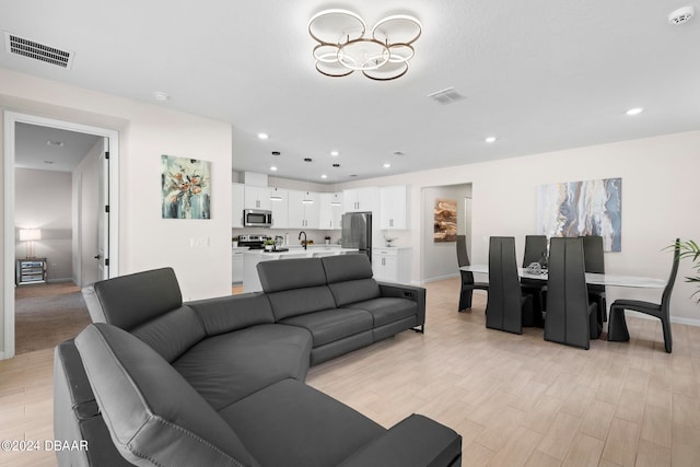 living room with sink and light hardwood / wood-style flooring