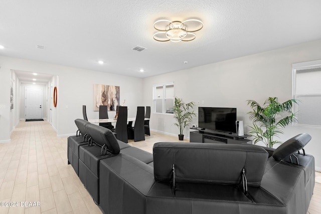 living room with light wood-type flooring and a textured ceiling