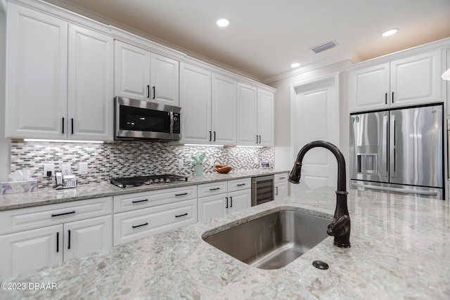 838 Attitude Ave, Daytona Beach, FL 32124 - kitchen featuring stainless steel appliances, ornamental molding, a sink, white cabinets, and wine cooler