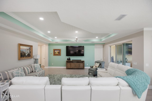 838 Attitude Ave, Daytona Beach, FL 32124 - living room featuring a raised ceiling, wood finished floors, ornamental molding, recessed lighting, and baseboards