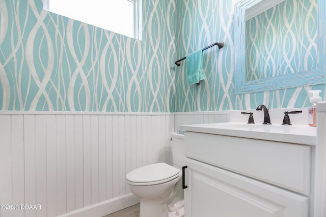 838 Attitude Ave, Daytona Beach, FL 32124 - bathroom featuring wallpapered walls, vanity, toilet, and a wainscoted wall