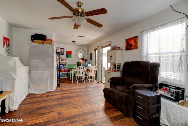 living room with dark hardwood / wood-style floors, ceiling fan, and a wealth of natural light