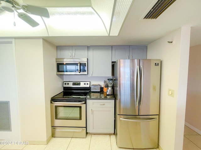 1513 Ocean Shore Blvd Unit C11, Ormond Beach, FL 32176 - kitchen with stainless steel appliances, light tile patterned floors, gray cabinets, dark countertops, and baseboards
