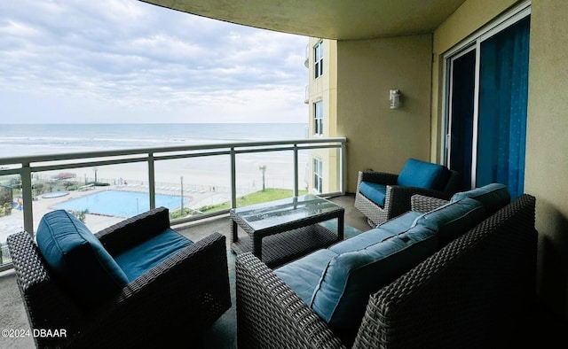 balcony with a beach view, a water view, and an outdoor hangout area