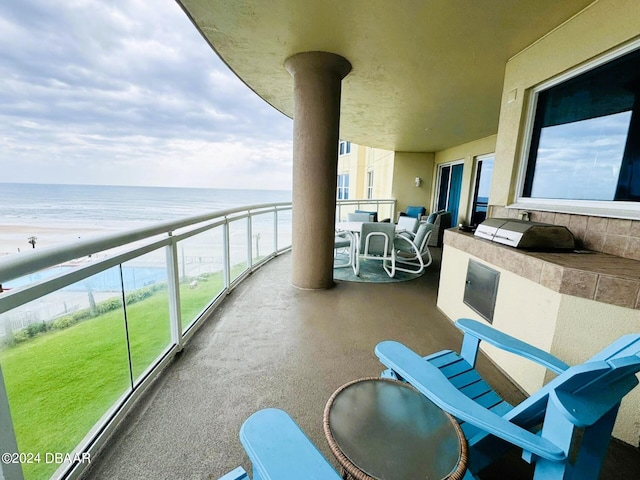 balcony featuring a view of the beach and a water view