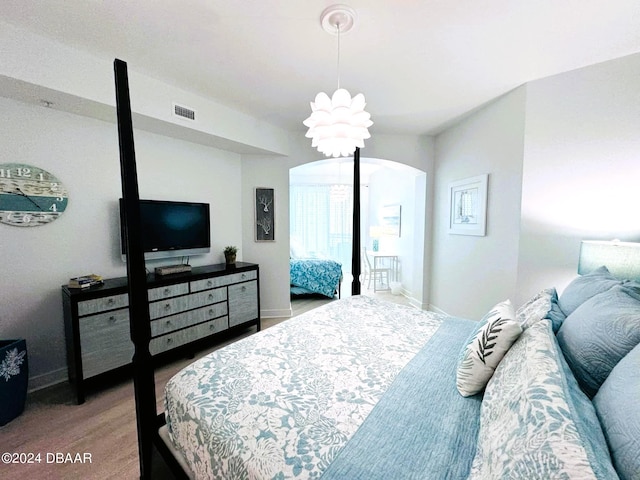 bedroom featuring light hardwood / wood-style floors and an inviting chandelier