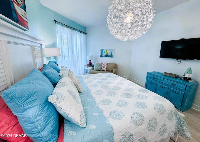 bedroom featuring light hardwood / wood-style floors and a notable chandelier