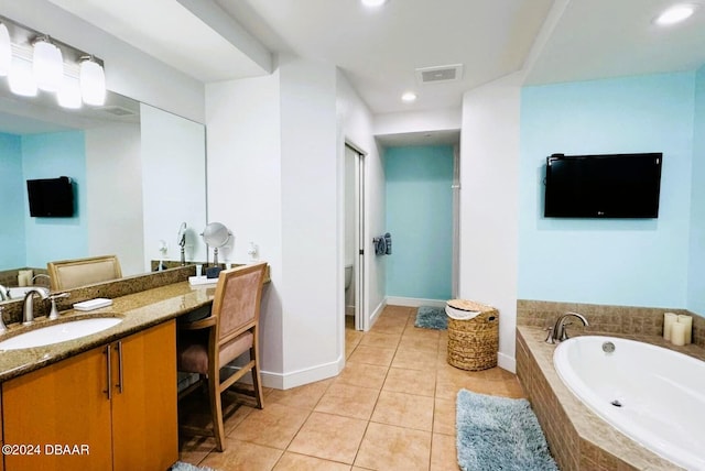 bathroom featuring vanity, a relaxing tiled tub, and tile patterned flooring