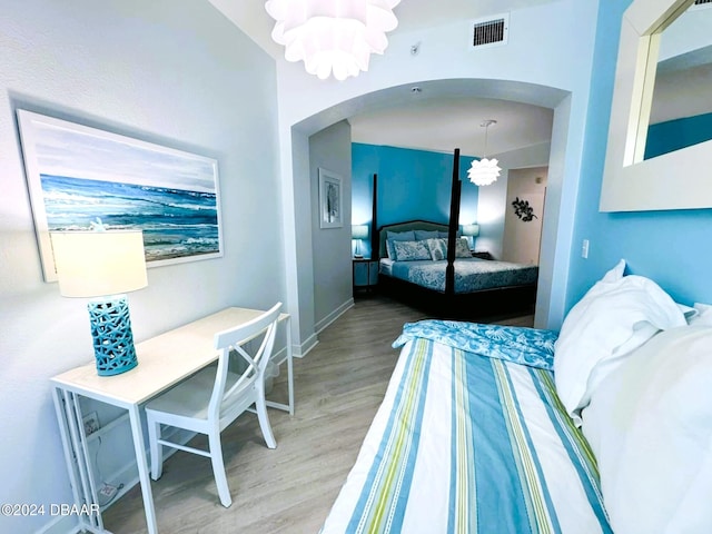 bedroom featuring hardwood / wood-style floors and an inviting chandelier