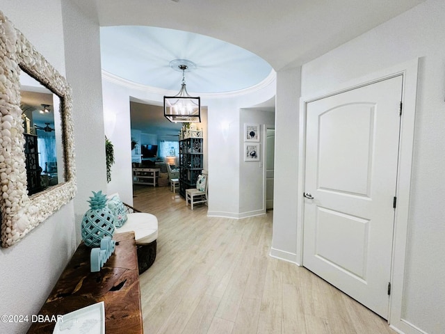 hall featuring a chandelier, light hardwood / wood-style flooring, and ornamental molding