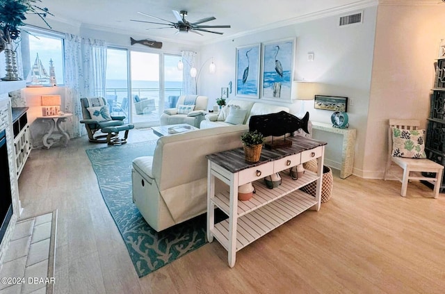 living room featuring hardwood / wood-style flooring, ceiling fan, and crown molding