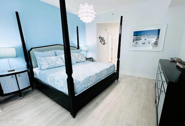 bedroom featuring a chandelier and light hardwood / wood-style floors