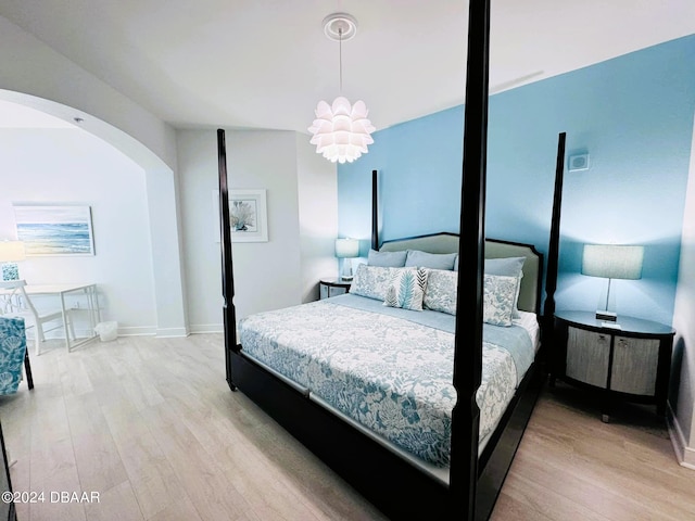 bedroom featuring light hardwood / wood-style floors and an inviting chandelier