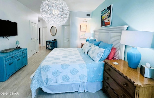 bedroom with a chandelier and light hardwood / wood-style flooring