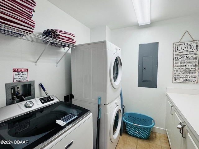 laundry room featuring stacked washing maching and dryer, electric panel, cabinets, and light tile patterned floors