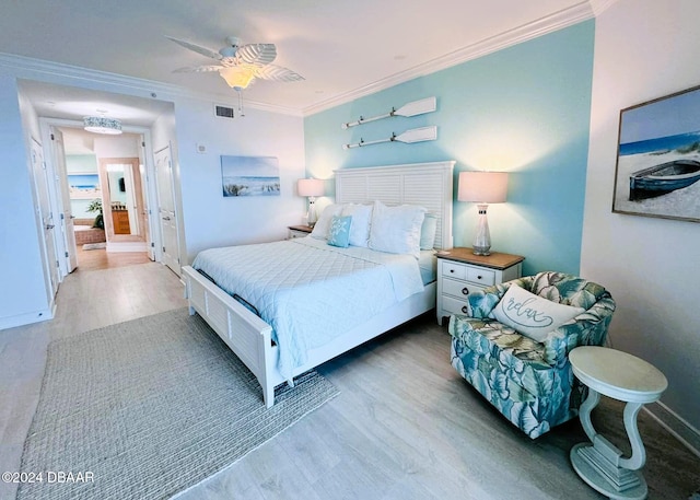 bedroom featuring hardwood / wood-style flooring, ceiling fan, and ornamental molding