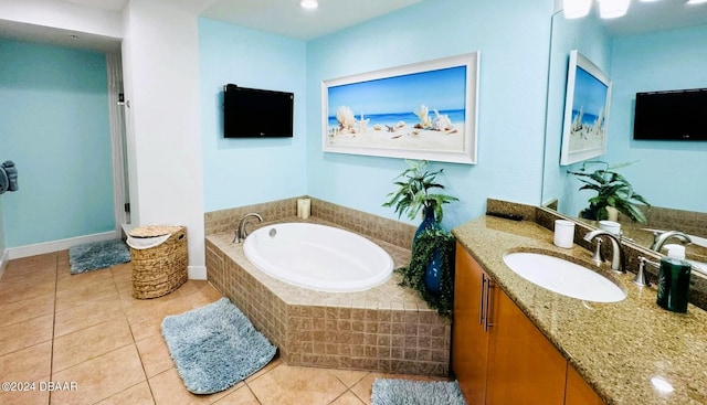 bathroom with tile patterned flooring, vanity, and a relaxing tiled tub