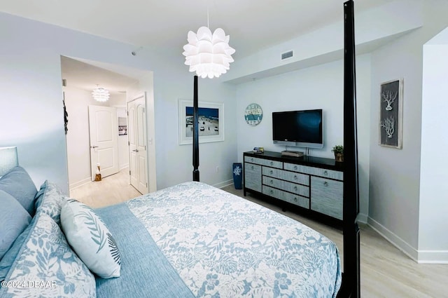 bedroom featuring light hardwood / wood-style floors and a chandelier