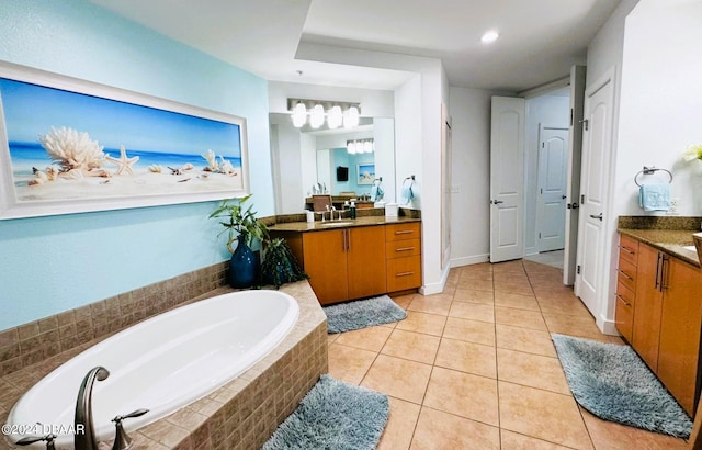 bathroom with vanity, tile patterned flooring, and tiled tub