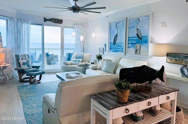 living room featuring ceiling fan, a water view, ornamental molding, and light hardwood / wood-style flooring