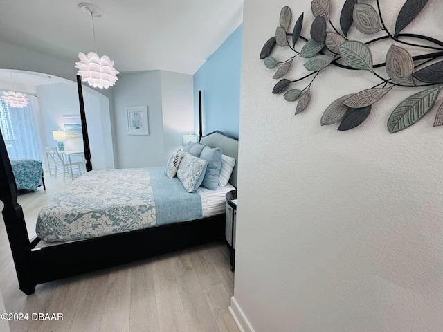 bedroom featuring a chandelier and light hardwood / wood-style flooring