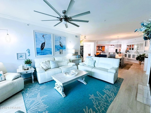 living room featuring hardwood / wood-style flooring, crown molding, and ceiling fan