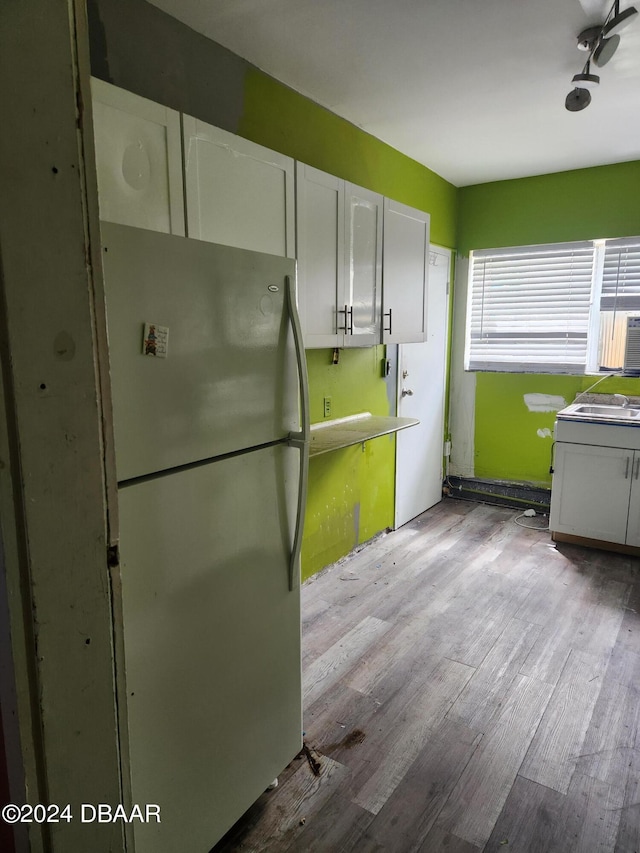 kitchen featuring white cabinets, fridge, and light wood-type flooring