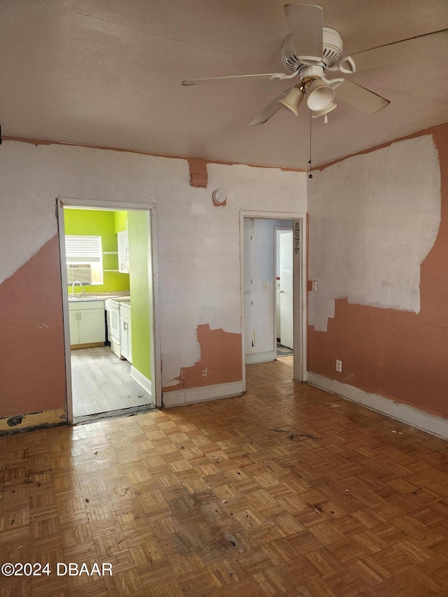 spare room featuring ceiling fan and parquet floors