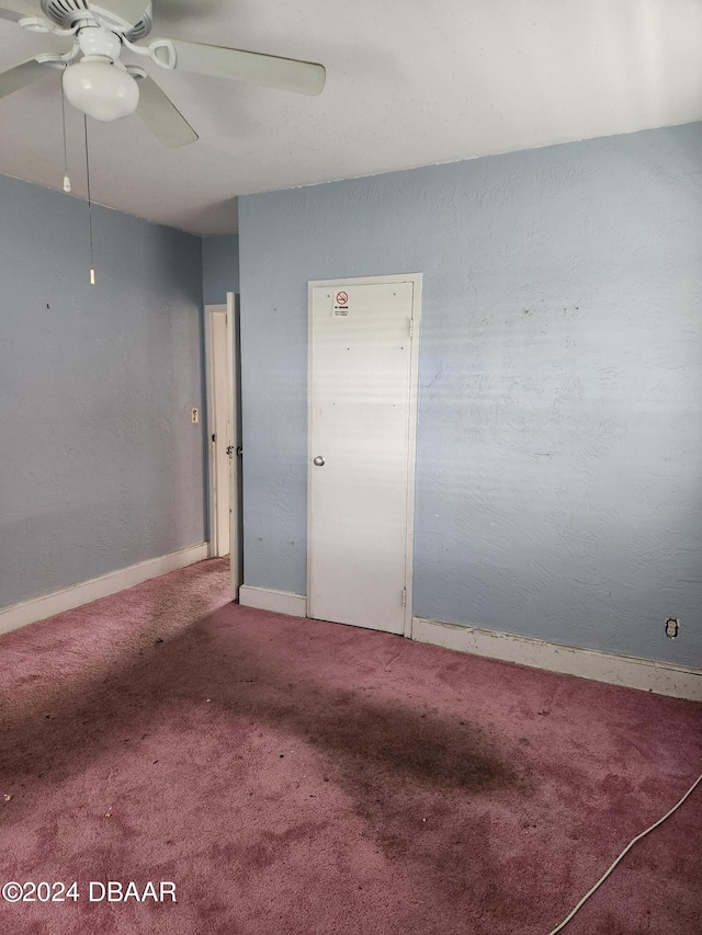 empty room featuring ceiling fan and carpet floors