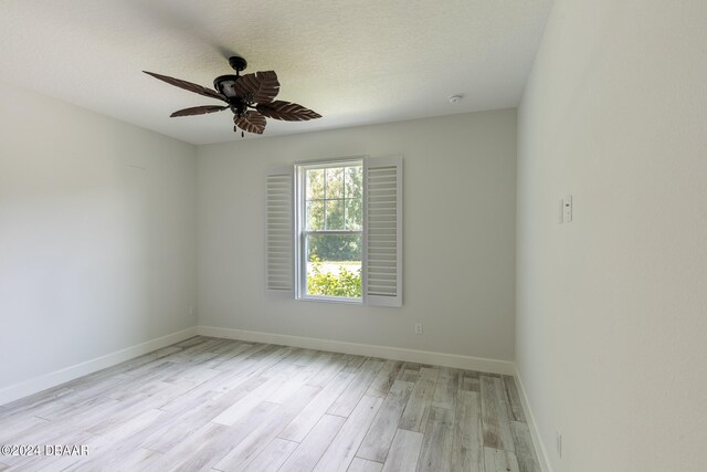 spare room featuring ceiling fan, a textured ceiling, and light wood-type flooring