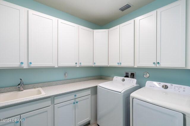 laundry area featuring cabinets, sink, and washing machine and clothes dryer