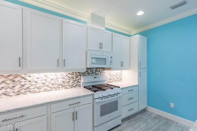 kitchen with ornamental molding, white cabinetry, light wood-type flooring, decorative backsplash, and white appliances