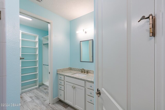 bathroom featuring vanity, hardwood / wood-style floors, and a textured ceiling