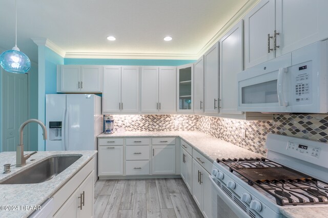 kitchen with white cabinets, pendant lighting, sink, and white appliances