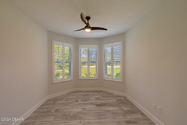 spare room featuring light hardwood / wood-style flooring, a textured ceiling, and ceiling fan