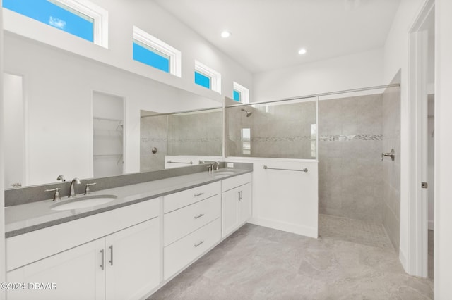 bathroom featuring double vanity, walk in shower, and a sink