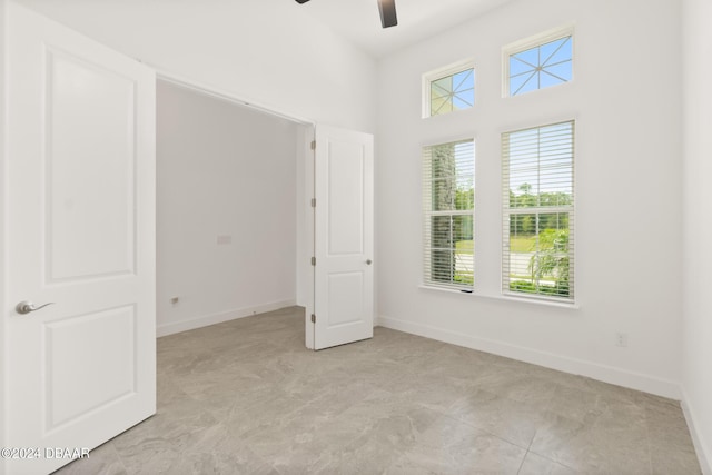 unfurnished room with a ceiling fan and baseboards