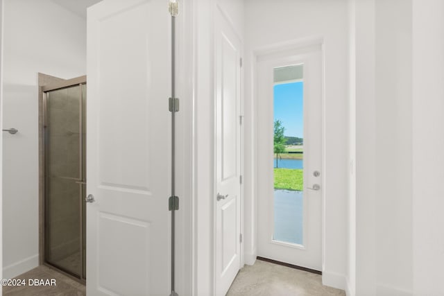 doorway to outside featuring a water view and baseboards