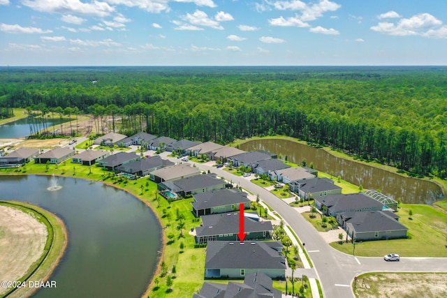 birds eye view of property with a residential view, a water view, and a view of trees