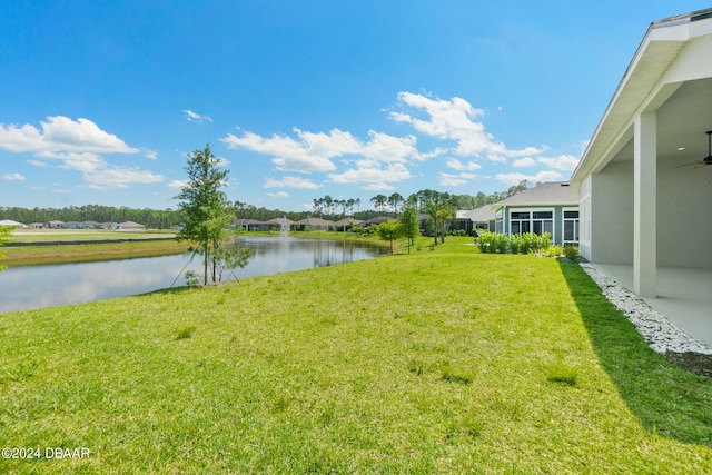 view of yard featuring a water view and ceiling fan