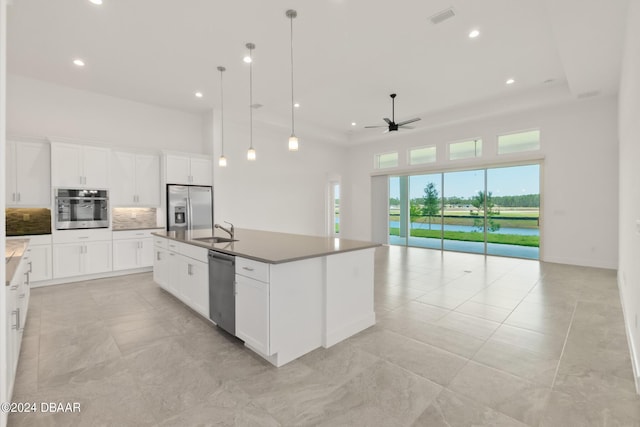 kitchen featuring a sink, visible vents, open floor plan, appliances with stainless steel finishes, and backsplash