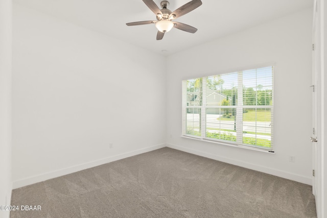 spare room featuring ceiling fan, carpet, and baseboards