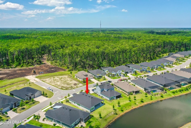 aerial view featuring a residential view, a water view, and a view of trees