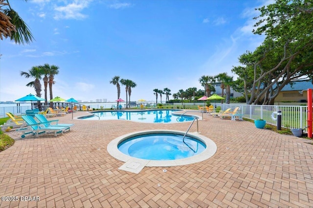 community pool with fence, a patio area, and a hot tub