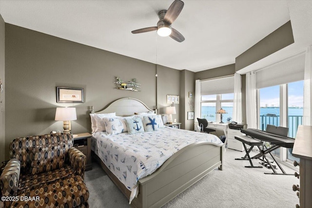 bedroom featuring a ceiling fan, carpet flooring, and a water view