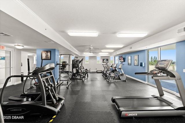 gym featuring baseboards, visible vents, a ceiling fan, and a textured ceiling